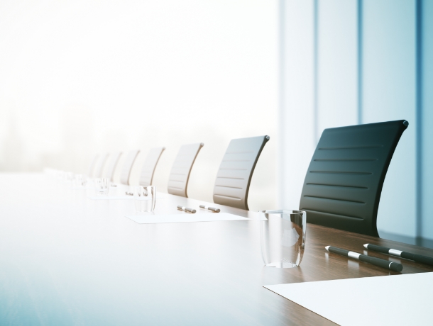 회의실에 의자와 컵, 펜 종이가 진열된 사진